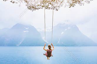 Dream concept, beautiful young woman on the swing