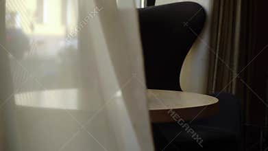 Bouquet of violet flowers on a table in hotel lobby, luxury house or restaurant. Curtain waving on a wind