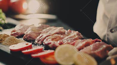 Cook`s hands sprinkle meat seasoning