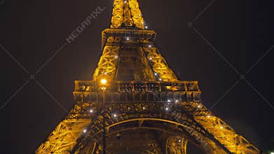 Parisian street and illuminated Eiffel Tower at night, France