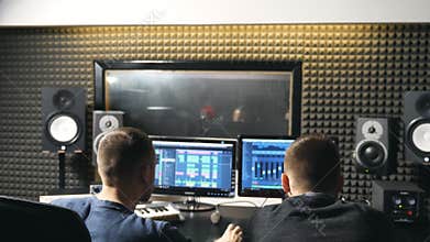 Unrecognizable young male audio editor and music producer working in the recording studio. Sound engineer creation a new