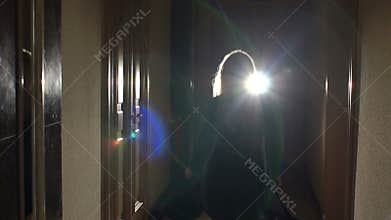 Silhouette of girl running in dark through tunnel.