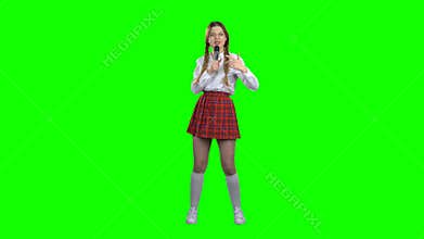 Teenager singer is singing a song. Green screen