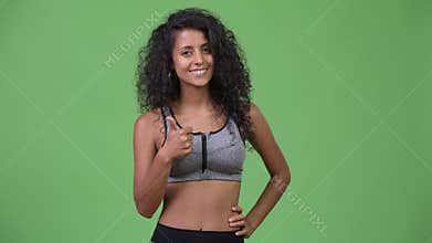 Young beautiful Hispanic woman with gym clothes giving thumbs up