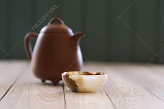 Healthy beverage concept. Chinese teaware: clay pot and onyx stone cup on white wooden table copy space. Minimalist style still