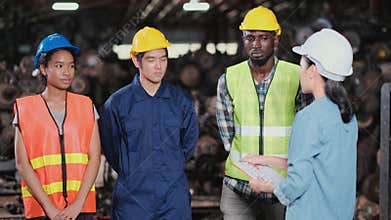 Manager woman remind the factory workers teams on implementation of the procedure in the automotive parts workplace area. Staff in