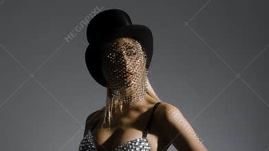 Young woman wearing top hat with sparkly veil and bustier