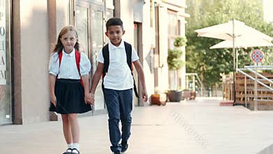 Children with backpacks come back from school and smiling.