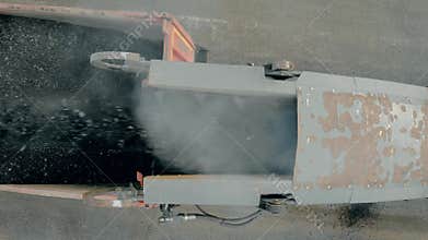 Close up of removing old layer of asphalt with milling and grinding machine. Road construction works. Paver pours