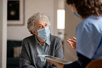Doctor home visit a senior woman during the covid-19 pandemic