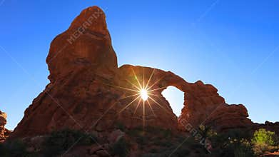 Sun burst through double arch window in Arches national park