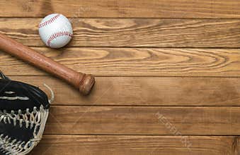 Baseball bat, glove and ball on wooden floor.  Sport theme background with copy space for text and advertisment