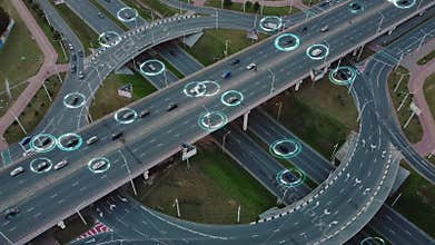View from drone: Self-driving autonomous electric cars of the future with HUD elements move along a busy traffic