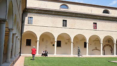 Tourists visit the portico of the cloister of the Franciscan monastery of Ravenna