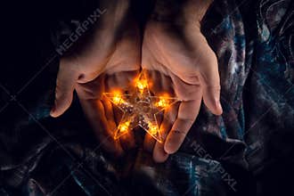 A shining star in folded palms.
