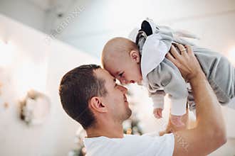 Father playing with baby in bunny costume.