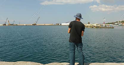 Mid adult man fishing at Aegean sea in Greece
