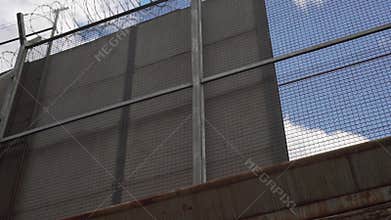 A high fence with barbed wire and spotlights. border fence