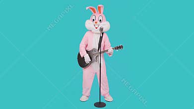 Funny musician guitarist plays music by acoustic guitar, singing song to retro vintage classic microphone, celebrates