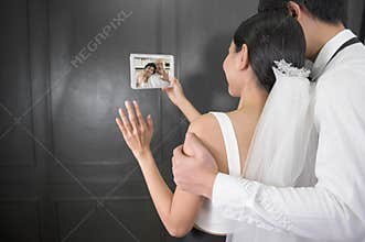 Couple in wedding gown are making video call with parents while quarantine . concept of wedding , telecommunication , covid-19