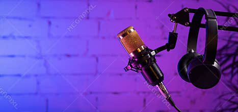 stand with microphone and headphones on brick wall background. online radio and podcasting concept. sound recording