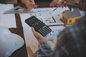 A team of construction engineers talks to managers and construction workers at the construction site. Quality inspection, work