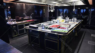 Steam fumes above vegetables and kitchen utensils