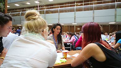 Girls and boys are sitting at table and