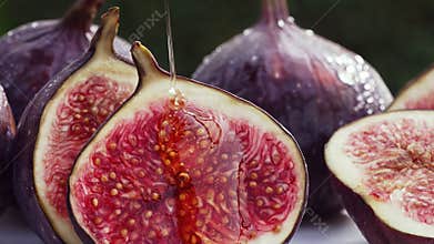 Close-up view of sweet golden honey flows on ripe figs slices. Healthy breakfast, natural dessert, juicy organic fig