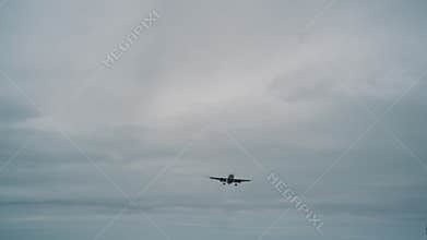Airplane in slow motion against a background of cloudy weather