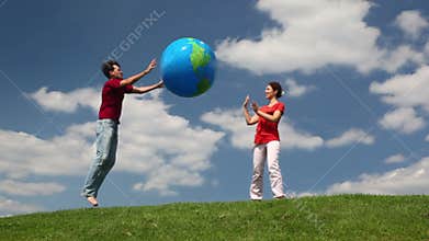 man and woman playing big inflatable ball on a