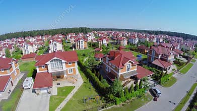 Cottage village near forest at sunny summer day.