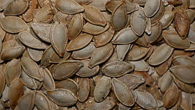 Close-up of pumpkin seeds rotating, highlighting texture and edges, macro