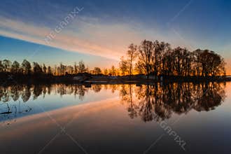 Rural summer sunrise landscape with river and dramatic colorful sky