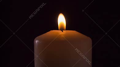 Burning candle in the dark