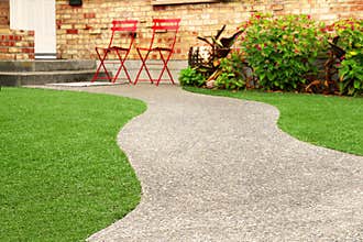 Walk way with Perfect grass landscaping with artificial grass in residential area
