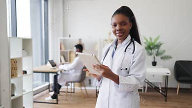 Female healthcare professional writing on tablet in modern clinic environment
