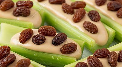 Ants on a log snack featuring celery sticks with peanut butter and raisins close up view