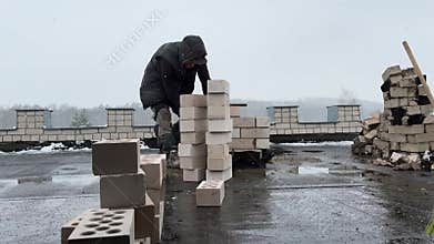 A stove fitter builds a chimney on the roof of a building. Construction of a heating stove