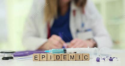 Wooden blocks show Epidemic word with medical syringes on top