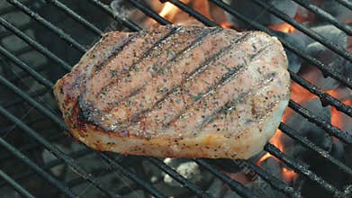 Juicy Pork Chop Grilling on a Hot Barbecue with Grill Marks
