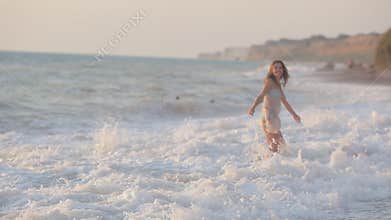 Happy girl runs along the beach and enjoys