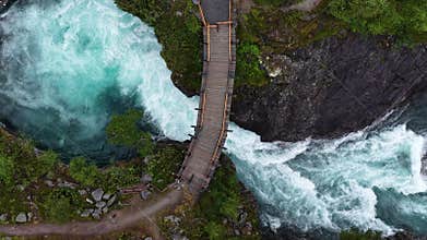 Aerial view of Tora River and wooden bridge at Billingen, Norway, with dramatic blue rapids below