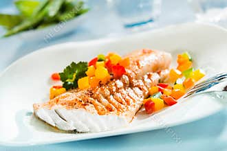 Grilled fish fillet with a colorful fresh salad