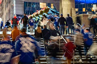 Blue Jays fans walking toward Rogers Centre before the baseball game at night.