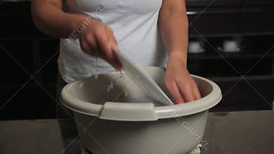 Woman Washing Kitchen Dishes by Hand in a Basin