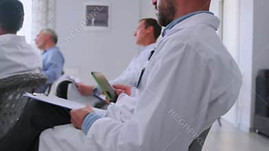 Doctors taking notes during medical seminar
