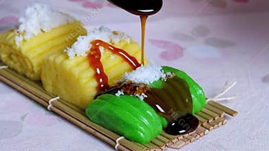 Pouring sweet palm sugar syrup on traditional Indonesian Getuk Lindri cassava cakes with coconut