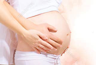 Pregnant belly with hands of mother and father