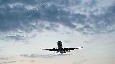Plane flying slow motion over head at sunset or sunrise